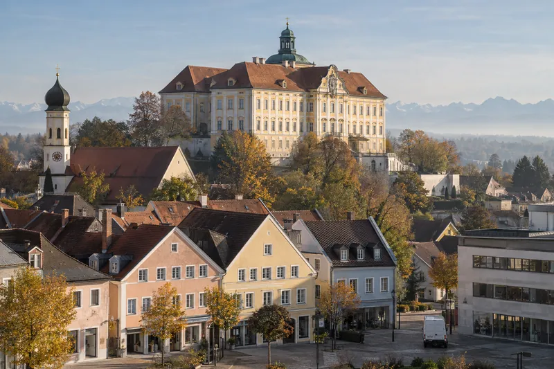 Dachauer Altstadt mit Geschäftshäusern unterhalb des Schlosses, im Vordergrund ein moderner Gewerbebau