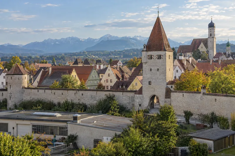 Altstadt von Kaufbeuren mit Stadtmauer, Turm und Gewerbebau im Vordergrund vor den Allgäuer Voralpen