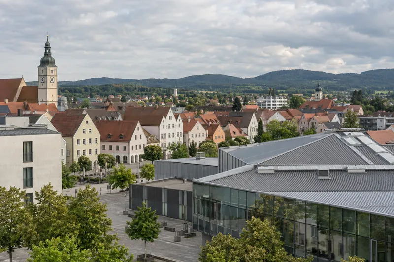 Verputzte Altstadthäuser am Residenzplatz Neumarkt und eine moderne Gewerbehalle mit Bürotrakt im Vordergrund