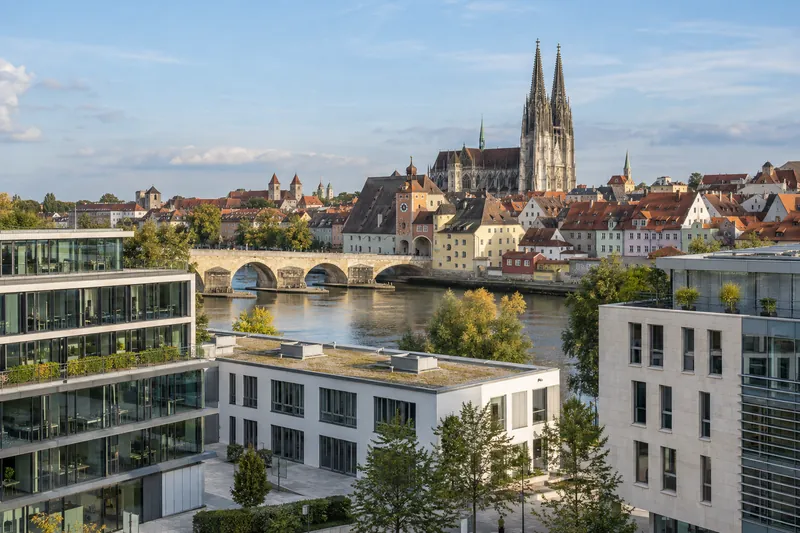 Moderne Büro- und Gewerbebauten in Regensburg mit Donau und Domtürmen im Hintergrund